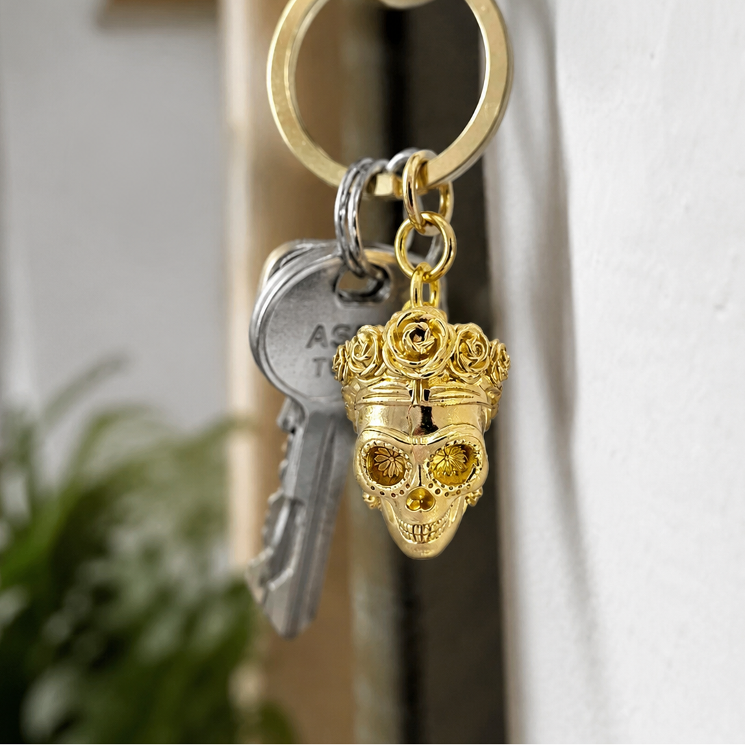 Close-up of Frida Kahlo skull brass keyring attached to keys showing the floral crown detail