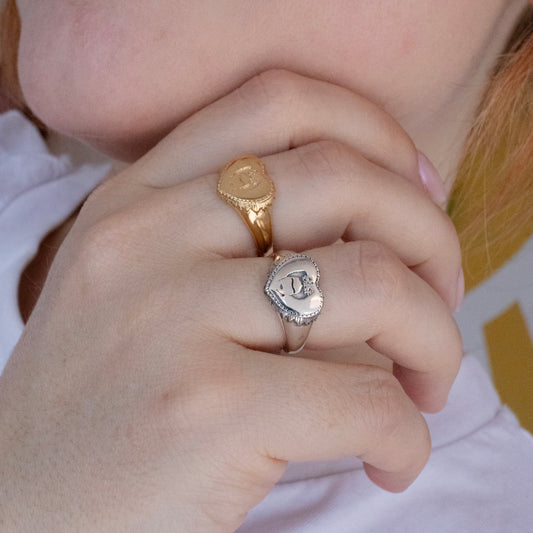 Hand wearing the Frida Heart Ring stacked with gold vermeil and silver rings, styled for everyday wear