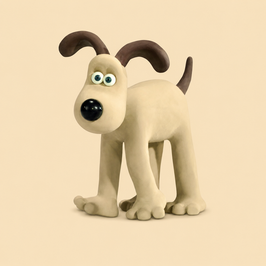 Wallace and Gromit Gromit dog figurine standing on all fours against a plain warm beige background. The dog is cream/beige with dark brown ears and tail, large blue-green eyes, and a glossy black nose.