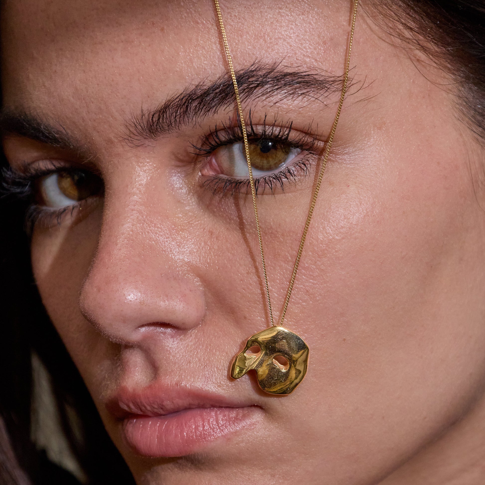 Licensed To Charm Model wearing large Phantom of the opera gold mask necklace on fine chain