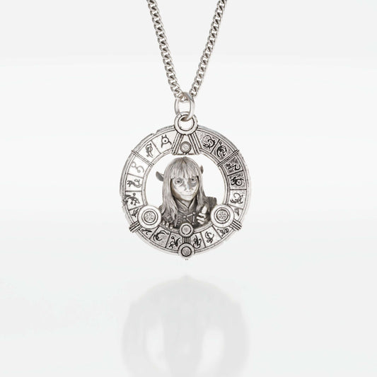 Silver necklace featuring Jen the Gelfling from The Dark Crystal, with long hair and urRu designed clothing, peering through a circle surrounded by mystical urRu symbols.