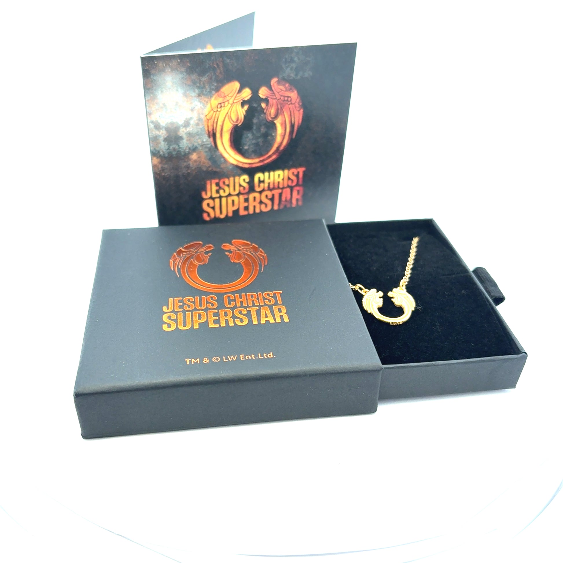 Officially licensed Jesus Christ Superstar gold logo necklace presented in branded gift box packaging on a white background.