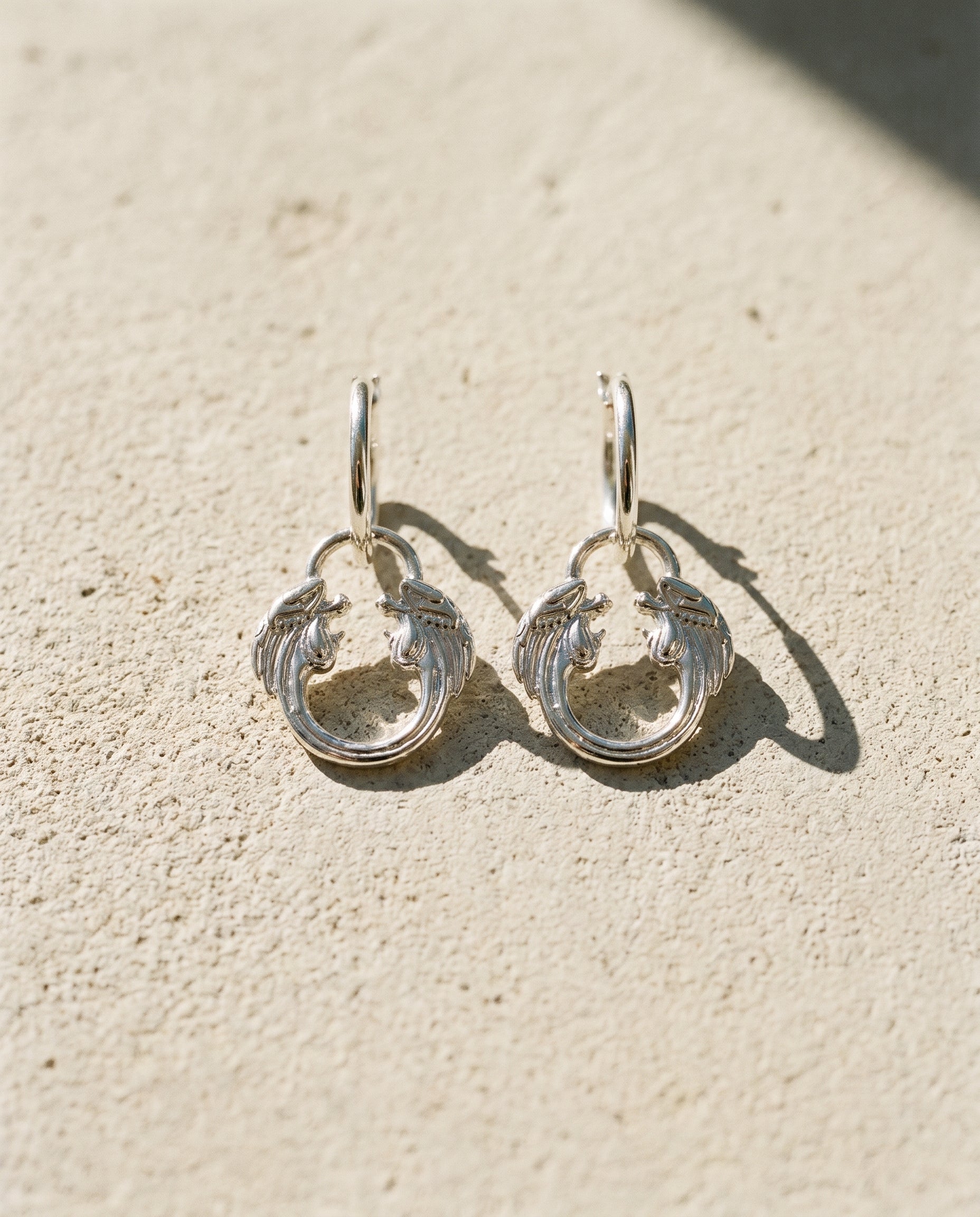 Jesus Christ Superstar silver plated hoop earrings styled in a lifestyle flat lay, official musical theatre jewellery gift.