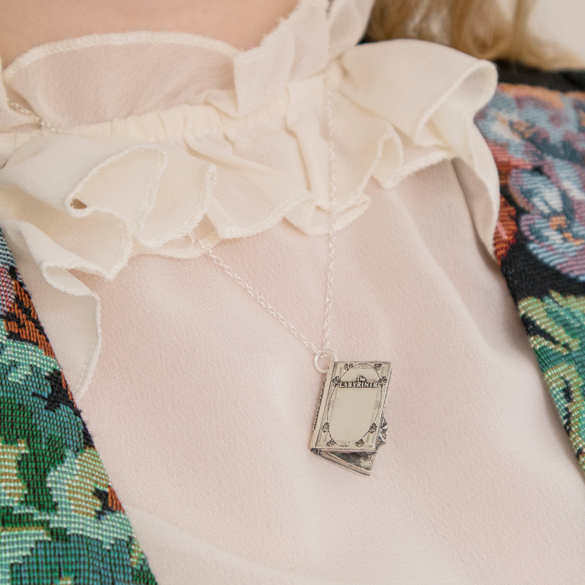 Labyrinth Character Book Charm Necklace in sterling silver, worn on model’s chest, handmade in the UK, officially licensed jewellery.