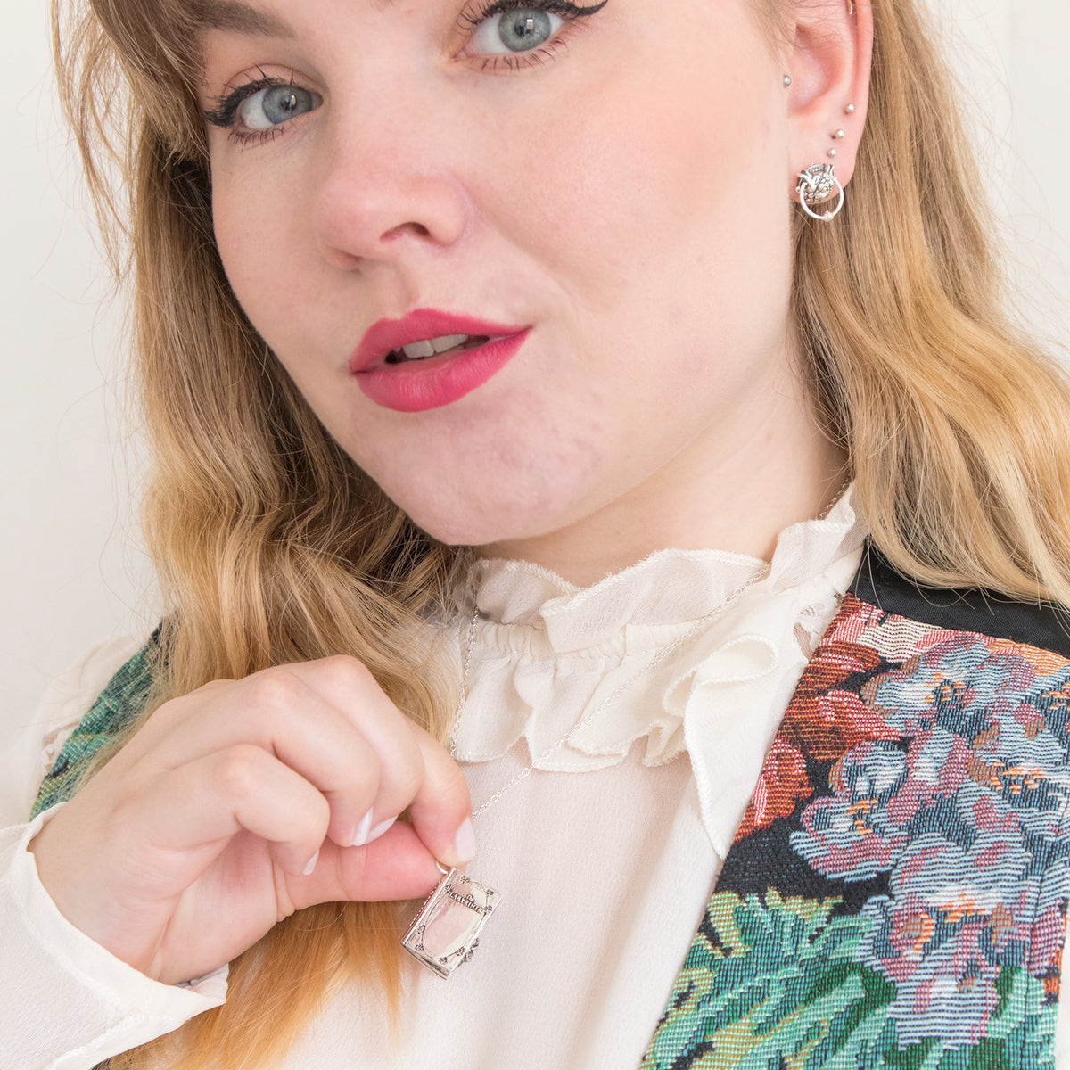 Model holding the Labyrinth Story Book sterling silver necklace pendant