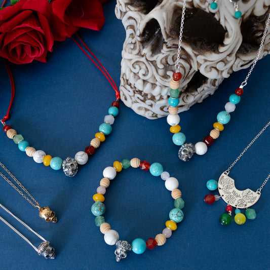 Flat lay of Licensed To Charm Frida Kahlo Beaded Sugar Skull Necklace with sterling silver skull charm and mixed colourful beads