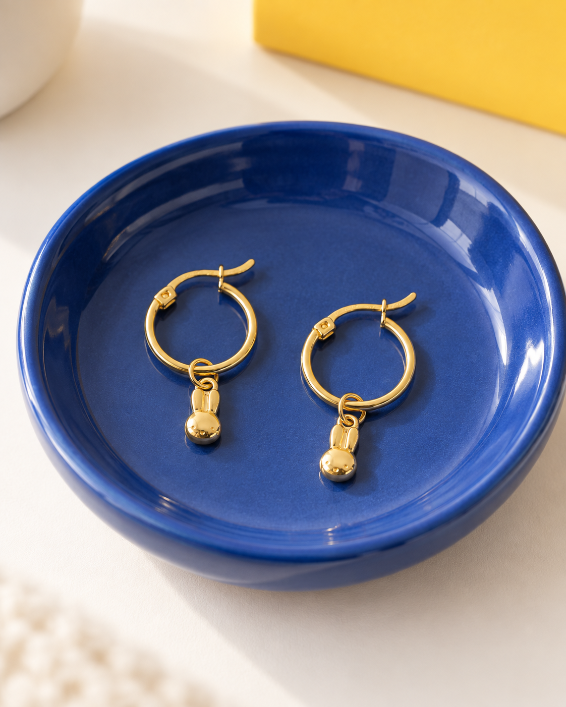 Pair of Miffy Mini Head Hoop Earrings in 18ct gold vermeil displayed in a cobalt-blue jewellery dish