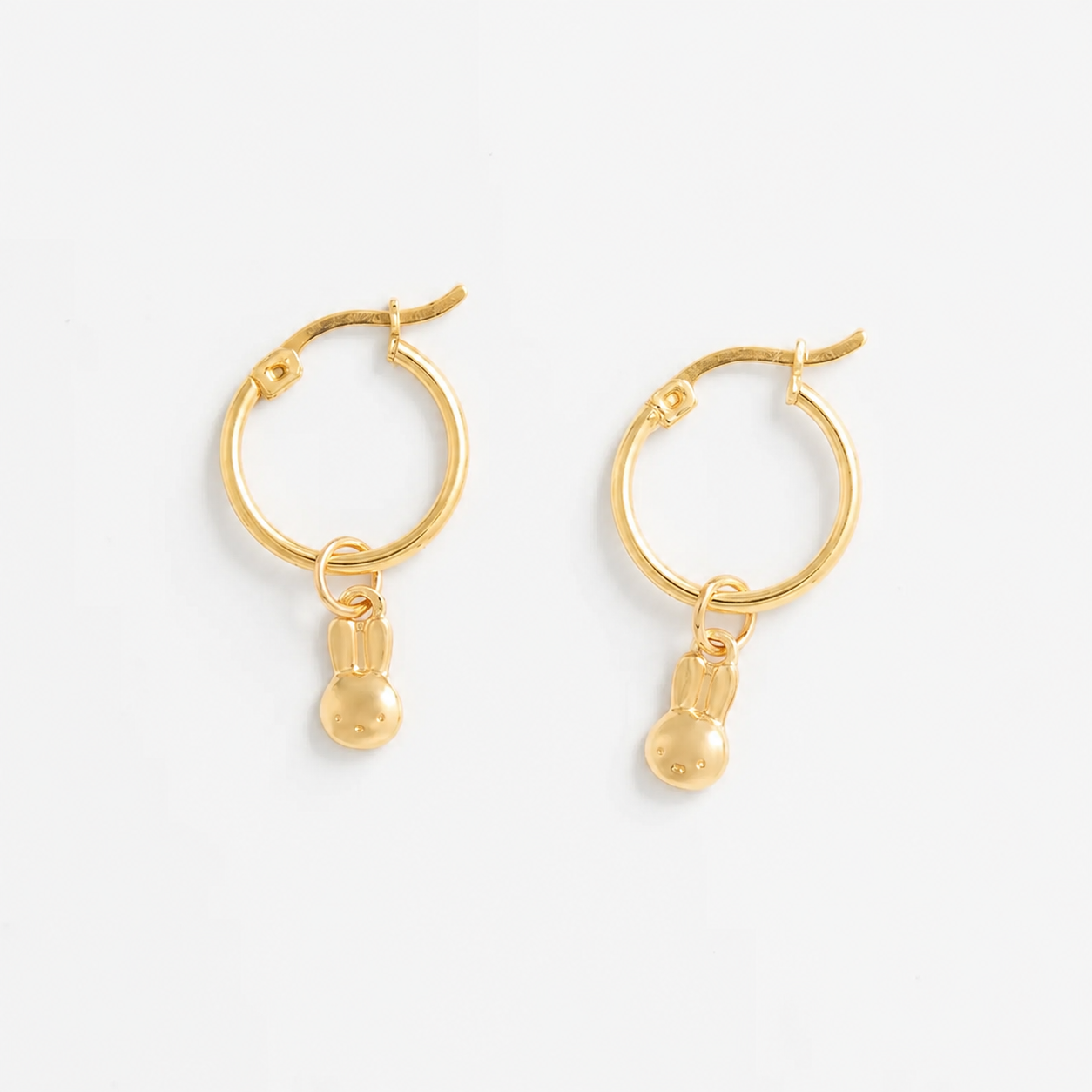 A pair of Miffy gold hoop earrings with small dangling miffy charms, shown on a clean white background.