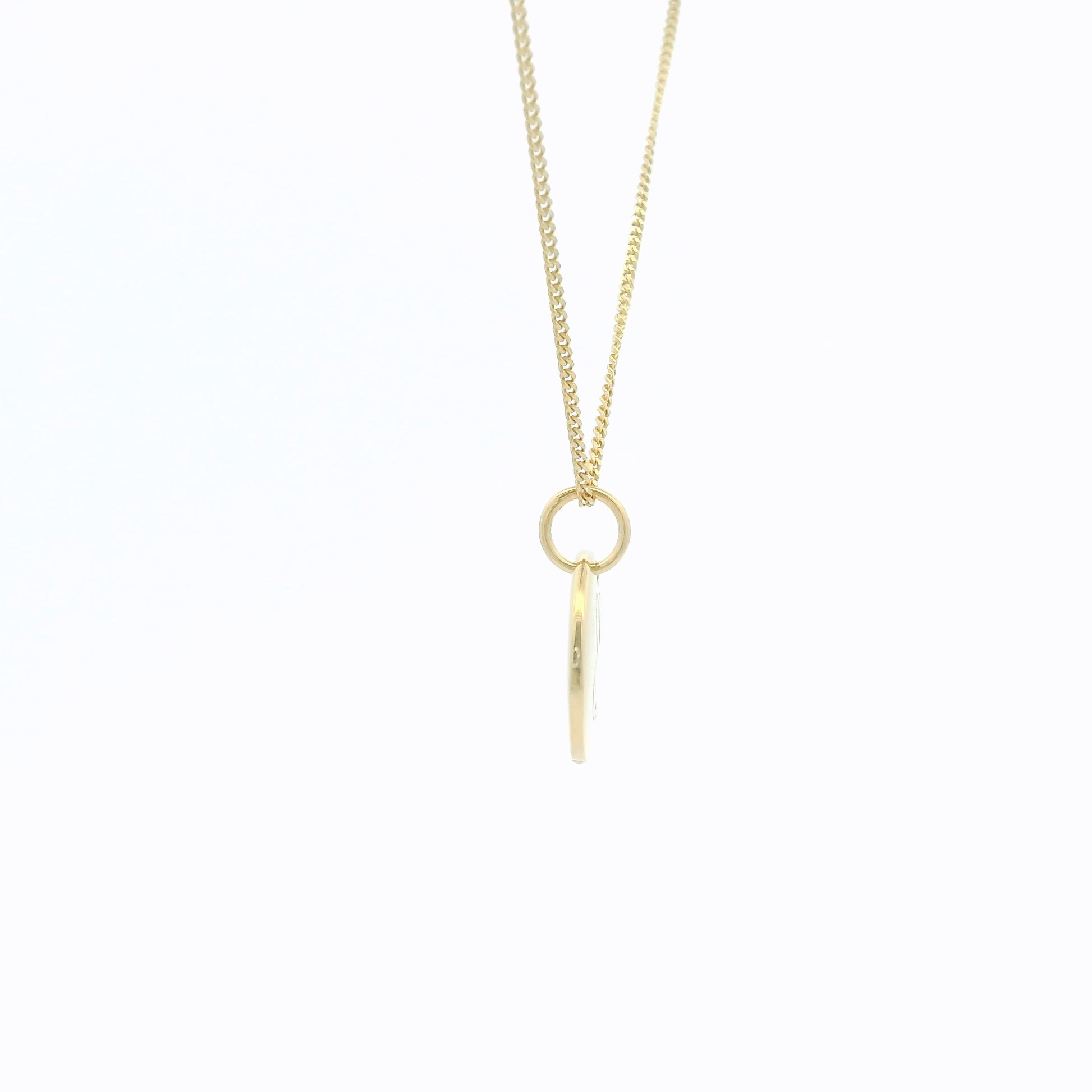 Gold necklace with a small round pendant on a white background