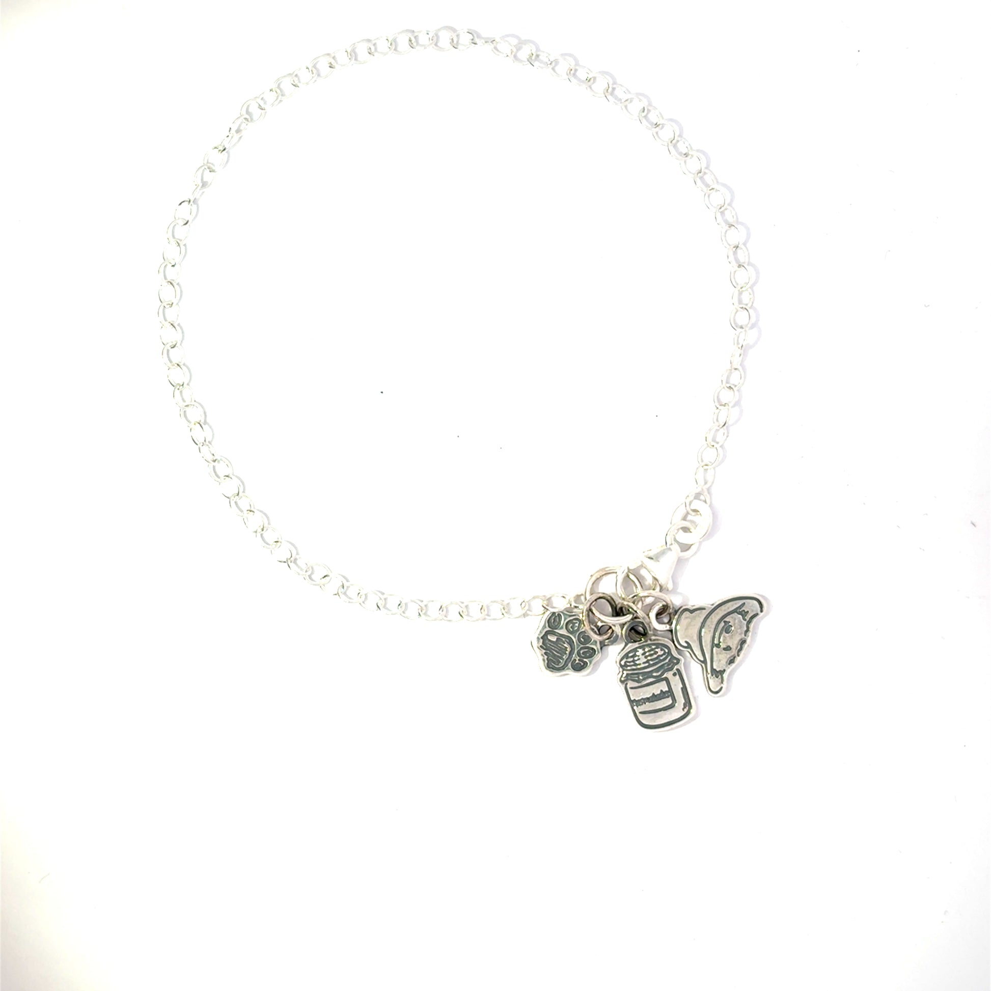 Licensed To Charm Paddington triple charm bracelet close-up — head, paw print and marmalade jar with oxidised detail