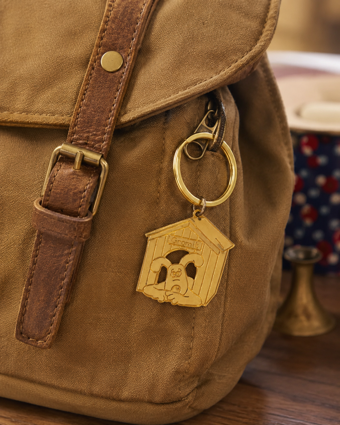 Licensed To Charm Wallace and Gromit Gromit doghouse keyring attached to the hardware of a casual canvas bag.
