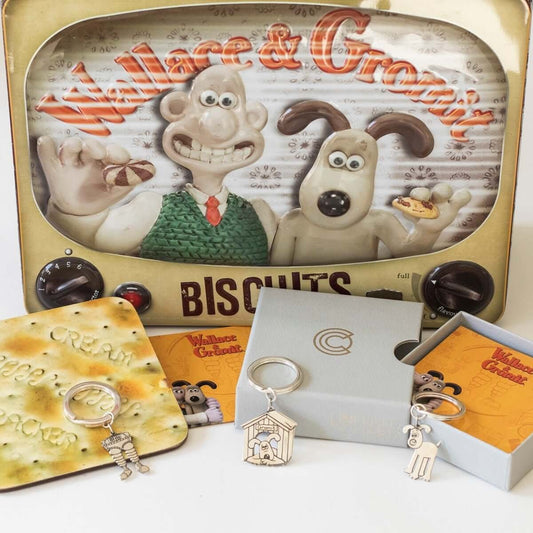 Licensed to Charm Gromit kennel keyring displayed with Wallace & Gromit artwork and silver gifts