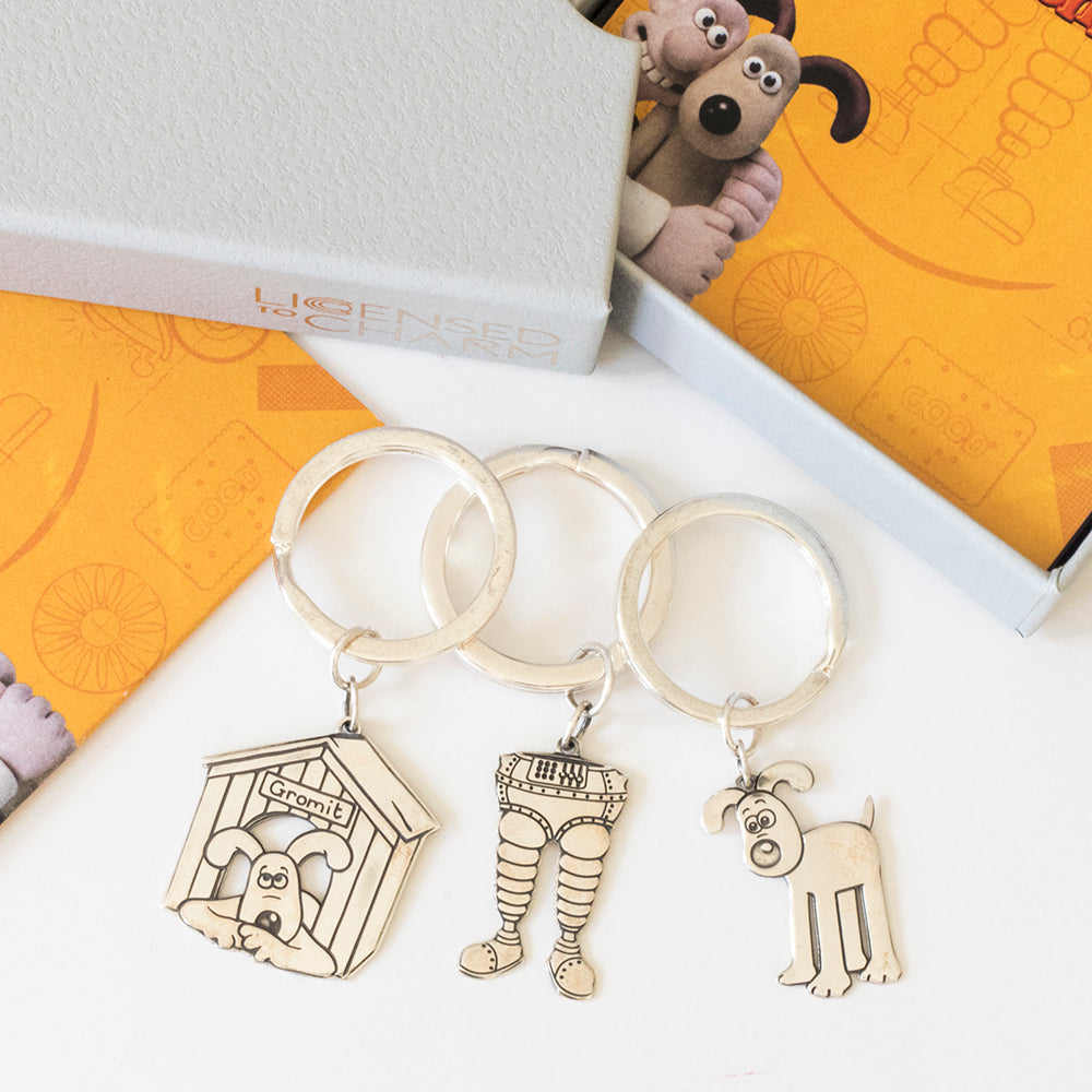 Licensed to Charm Wallace & Gromit sterling silver character keyrings arranged in a studio flat lay