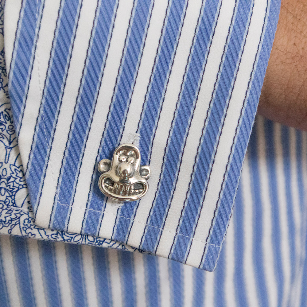 Licensed To Charm Wallace sterling silver cufflink worn on the cuff of a blue striped shirt