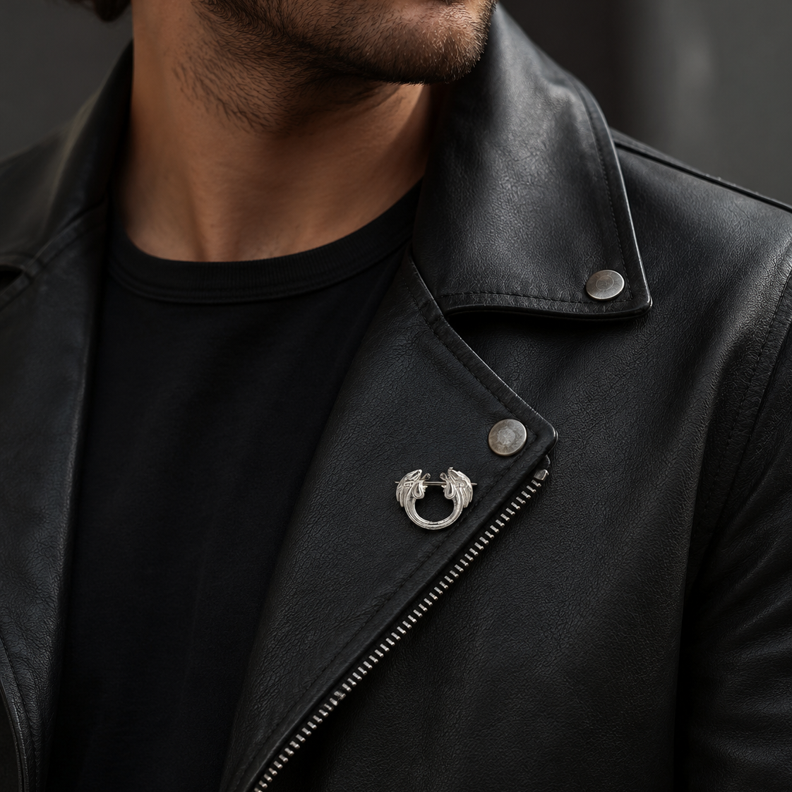 Stylish man wearing a decorative sterling silver pin brooch on a black leather jacket as a subtle show-inspired accessory