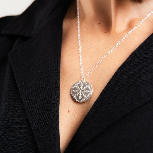 Close-up of the sterling silver Solid Lace Necklace highlighting the detailed lace engraving and polished finish.