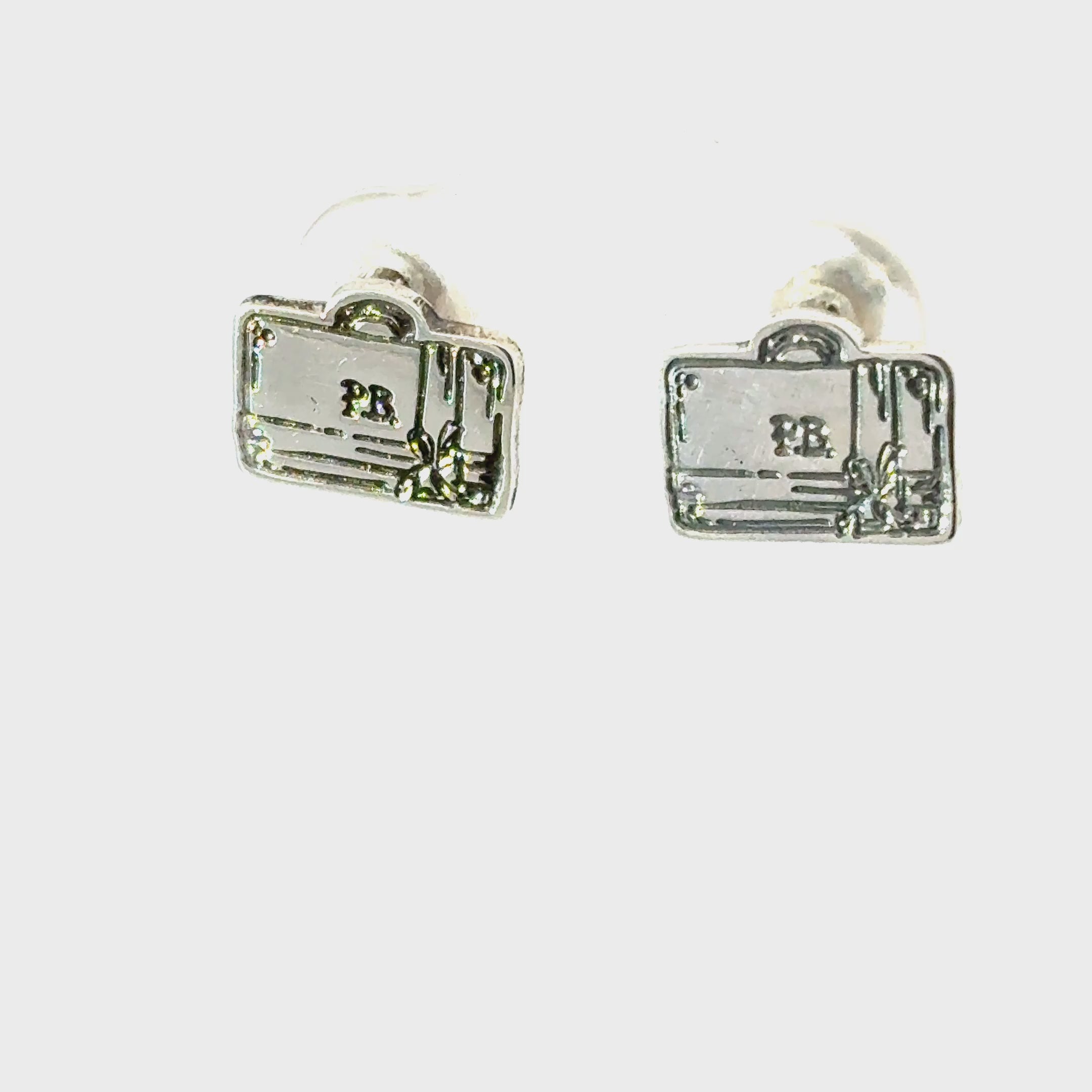 Close-up of sterling silver Paddington suitcase earrings with bow detailing, handcrafted by Licensed To Charm