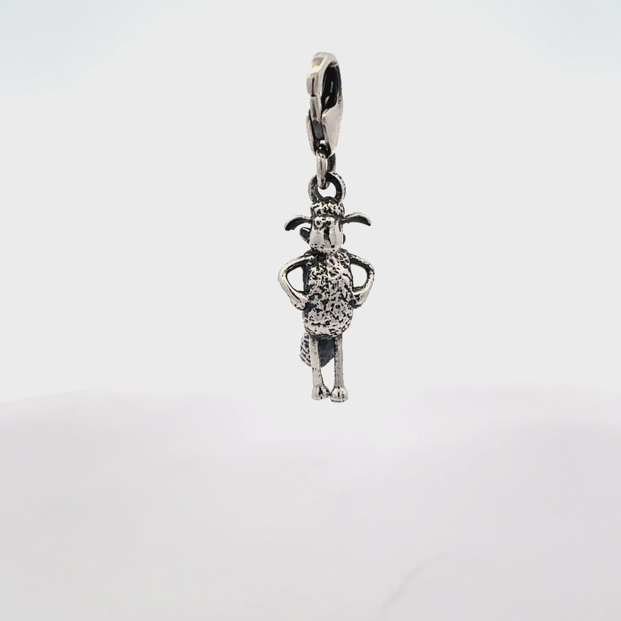 Angled view of Shaun the Sheep sterling silver clip-on charm highlighting sculpted character details