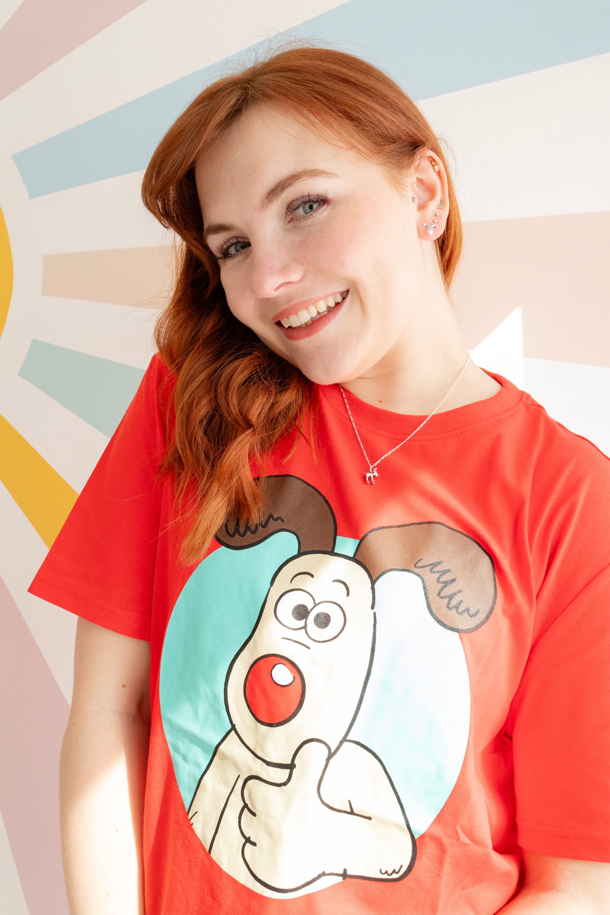Model wearing the Standing Gromit necklace in sterling silver, a handmade Wallace and Gromit jewellery gift.