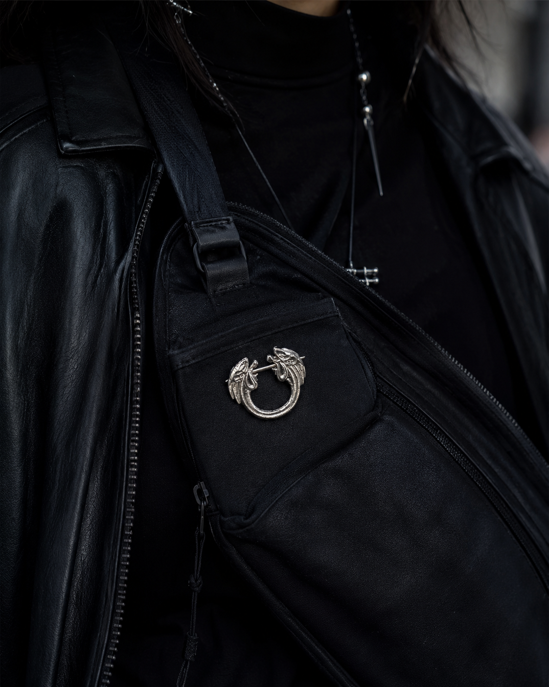 Decorative sterling silver pin brooch attached to a black crossbody bag as a collectible fan accessory.