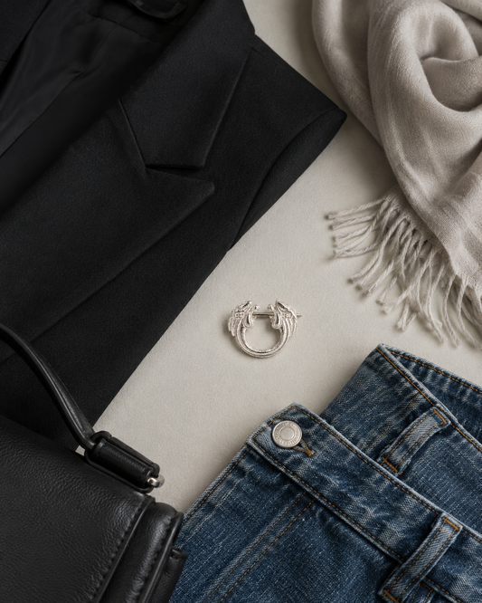 Sterling silver decorative pin brooch shown in a styling flat lay with blazer scarf denim jacket and bag