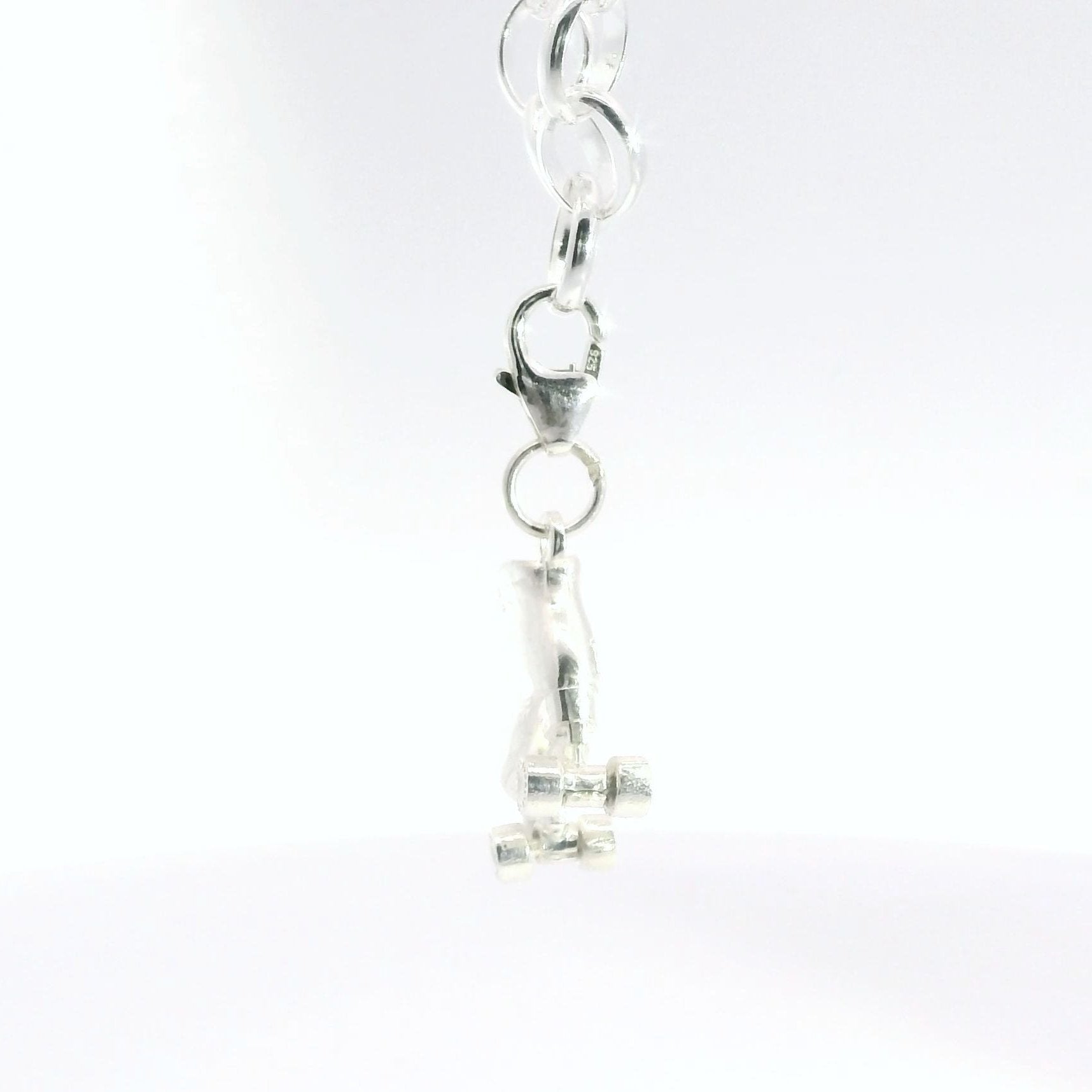 Close-up of sterling silver roller skate charm bracelet featuring a finely detailed miniature skate design.